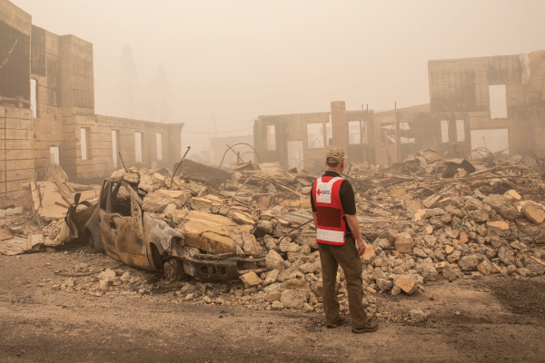 A Red Cross volunteer inspects damage after a wildfire