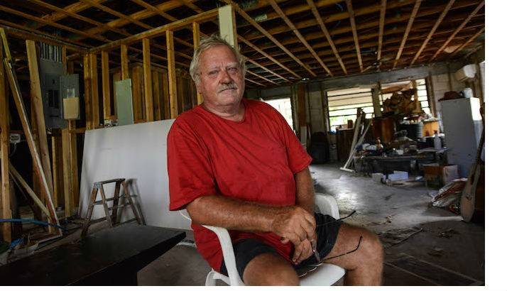 Dennis sitting in a chair in his home.