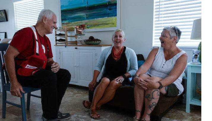 Leslie and Sharlene chatting with a Red Cross volunteer inside of their home.