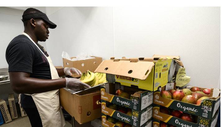 SOS Foundation’s Community Kitchen staff packing fruit in boxes in their kitchen.