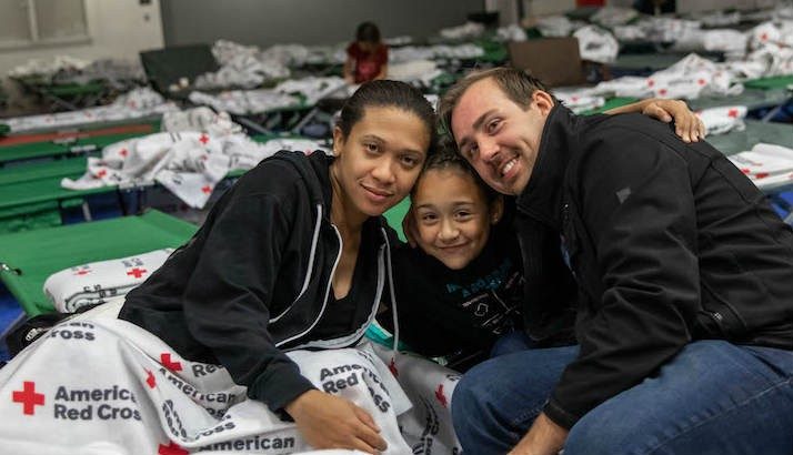 A family smiling inside of a shelter.