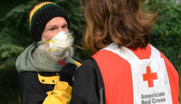 A Red Cross volunteer assisting a resident affected by wildfires.