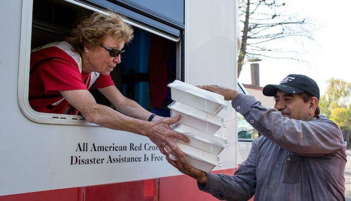 Santa Rosa resident Gabino Gonzalez gets hot lunches for his family from a Red Cross volunteer.