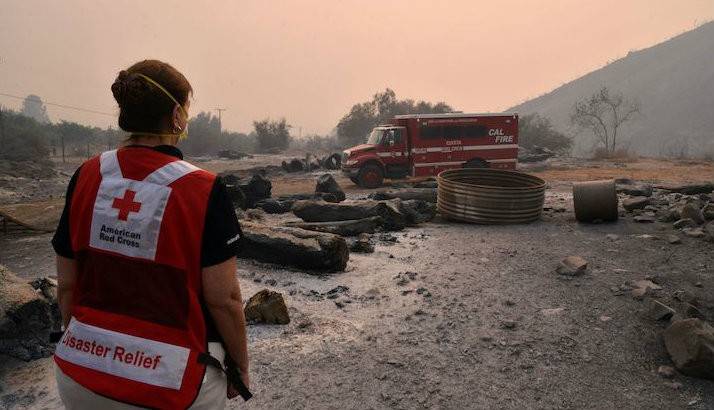 Thick smokes chokes out the sun as disaster volunteer Vicki Eichstaedt walks near burned out areas of the Los Padres National Forest.