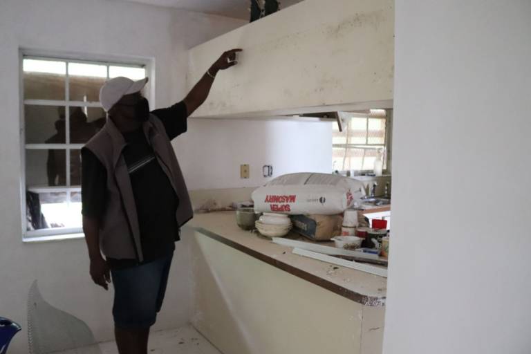 Allison Stuart points to the water damage line inside of his home.