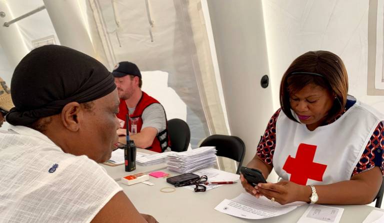 A Red Cross volunteer looking at her phone.