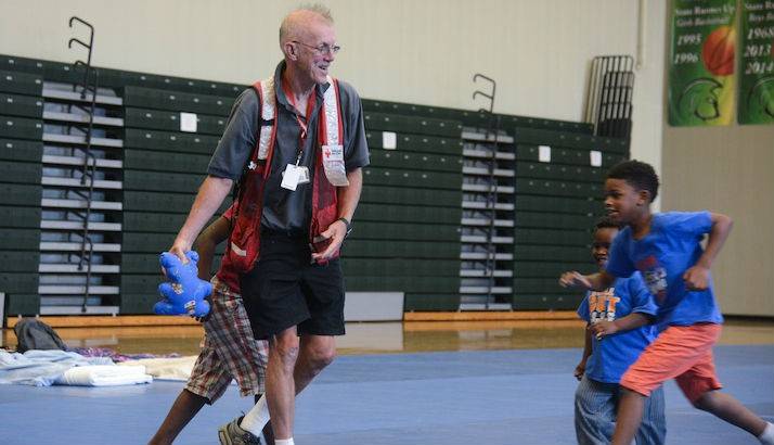 American Red Cross volunteer Tom Quinn plays a vigorous game of catch with some of the younger residents of the evacuation shelter.