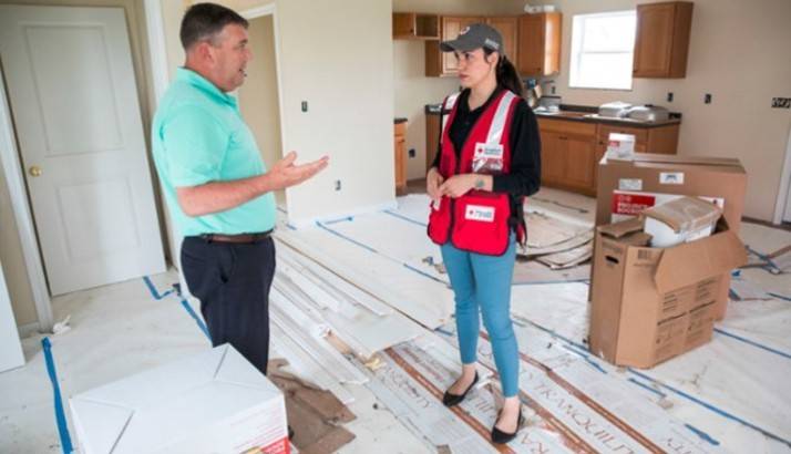 A Red Cross survivor talking to a man about recover efforts.