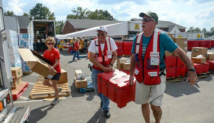 Red Cross volunteers loading emergency response vehicles with food, water and snacks.