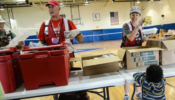 Red Cross volunteers serving hot meals for lunch and dinner to residents.