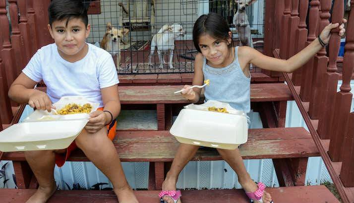 Kids receiving hot dinners from the Red Cross truck.