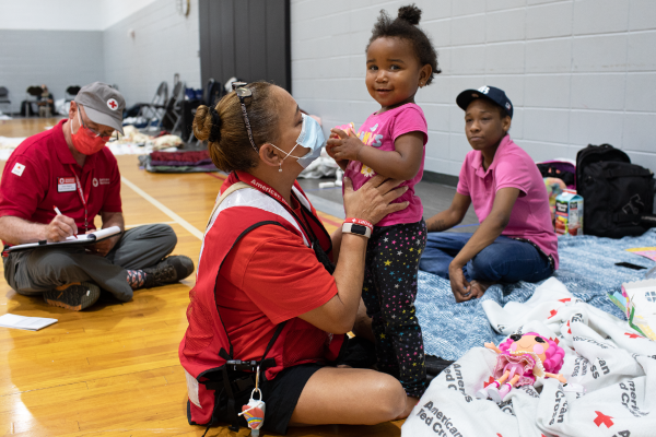 Red Cross volunteer Martha Narvaez entertains Serenity, age two, at the Red Cross Evacuation Shelter in Clearwater, Fl..