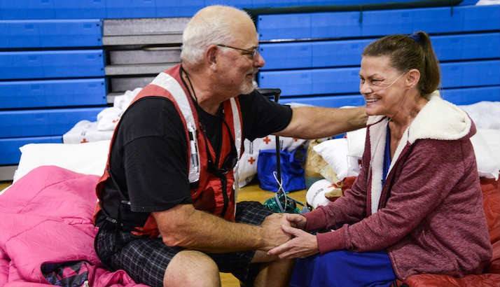 Red Cross worker Chuck Parker plugged in Donna's oxygen concentrator at a shelter.