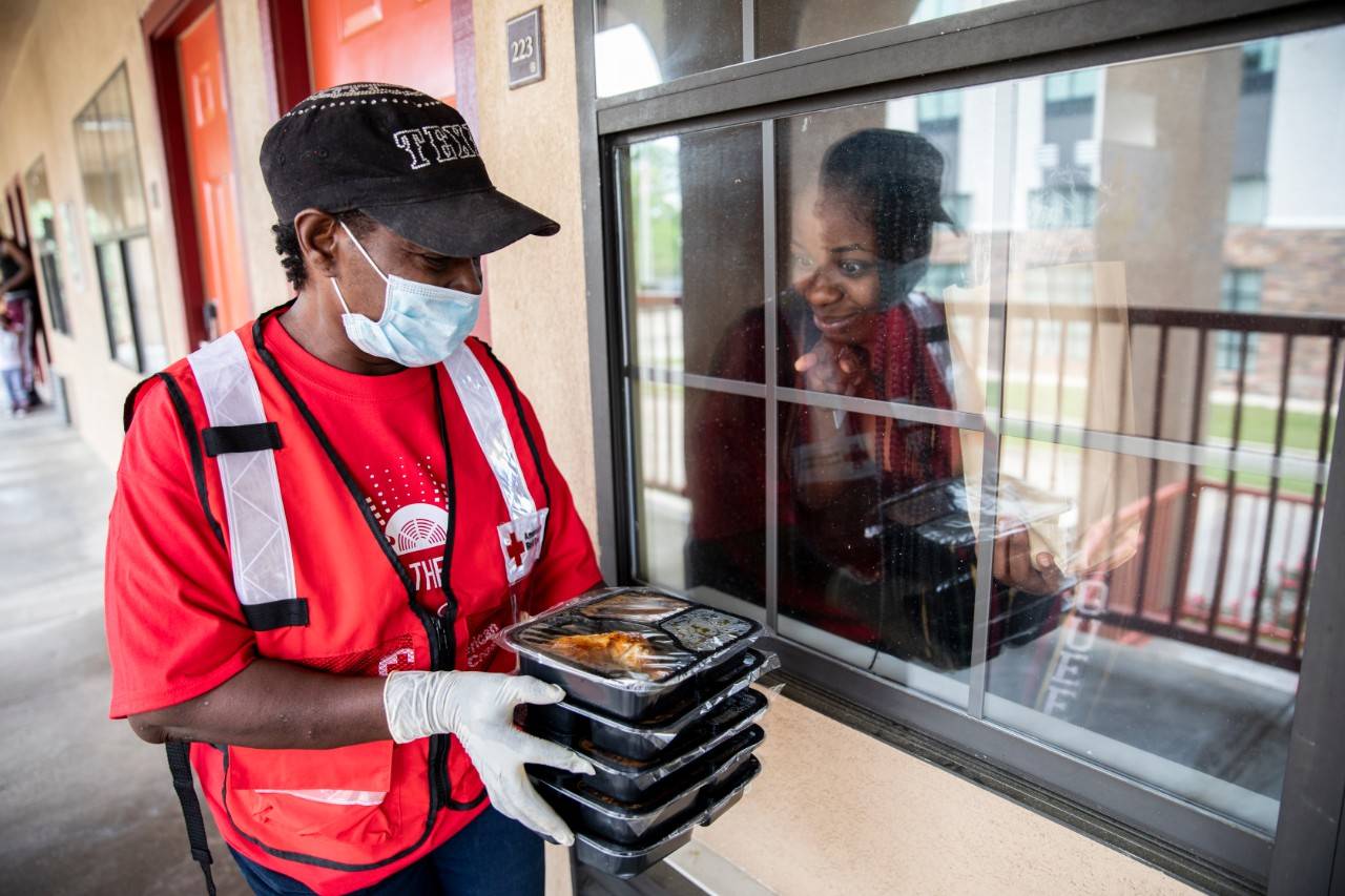 April 17, 2020.  Monroe, Louisiana.Sandra White of the American Red Cross brings a meal for Briana Shanklin who is staying at a hotel where the Red Cross is providing shelter for people for people affected by a recent tornado in Monroe, LA on Friday, April 17, 2020. Hundreds of residents needed shelter after the storm. Normally the Red Cross would set up shelters but due to the Covid-19 pandemic and social distancing guidelines people who were unable to remain in their damaged homes after the storm, have been given rooms in various local hotels.Photo by Scott Dalton/American Red Cross