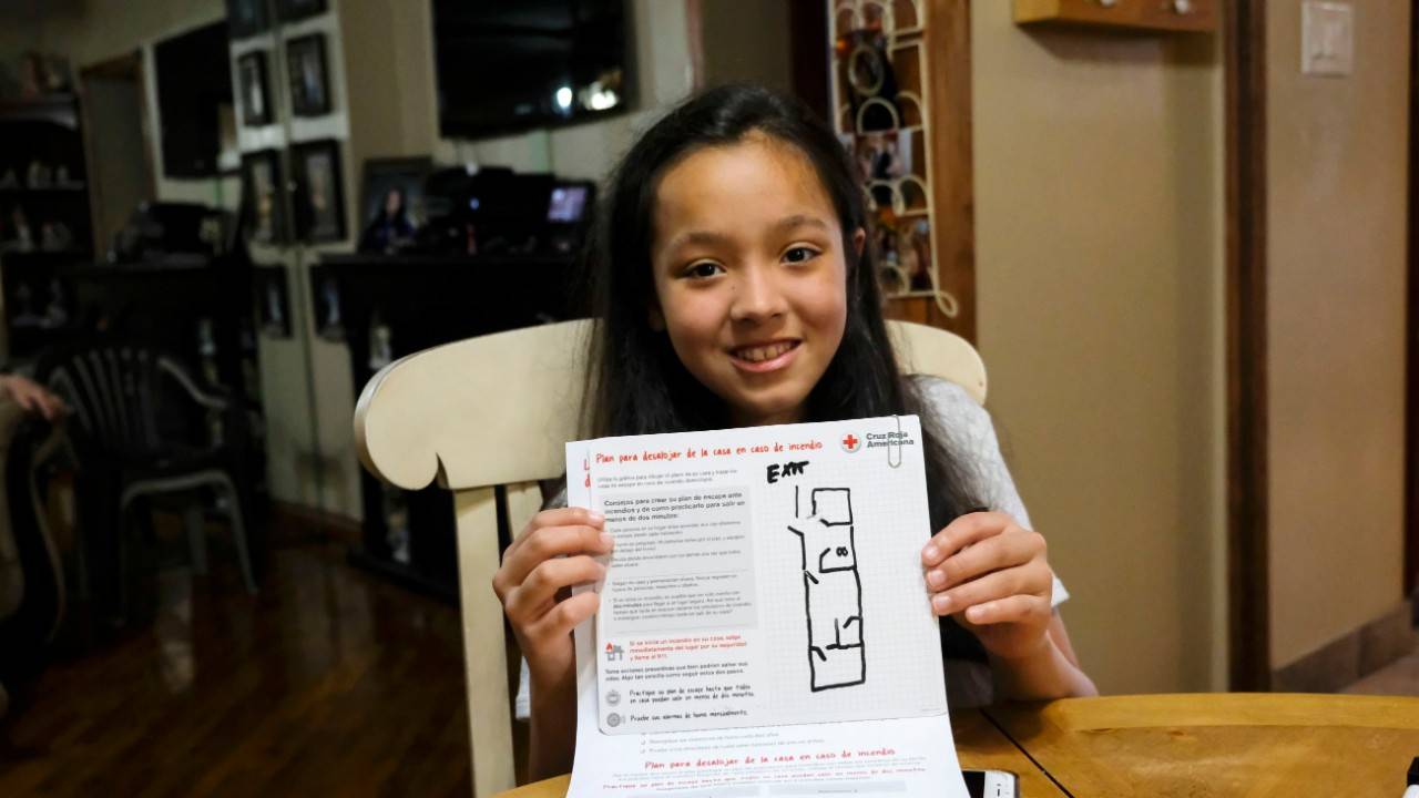 May 12, 2018.
Brooklyn, New York. 
Smoke alarm installation - Sound the Alarm.
Pictured: Gabriella Rios  

Young Gabriella Rios shows off the Home Fire Escape Plan she and her mother drew up with the help of American Red Cross volunteers in Brooklyn, New York. The Escape Plan shows the family the best ways to get out of their home in the event of a fire.

The Red Cross volunteers also provided fire prevention information and installed new smoke alarms in the Rios home during an event called "Sound the Alarm." 

During "Sound the Alarm" events teams of Red Cross volunteers spend the day installing free smoke alarms in private homes throughout a city. These events are held across the country to install smoke alarms in as many homes as possible, and to educate families about how to prevent, and escape from, a home fire. All alarms and educational services are provided free-of charge to any home that needs them.

Photo by Luiz Ribeiro for the American Red Cross.