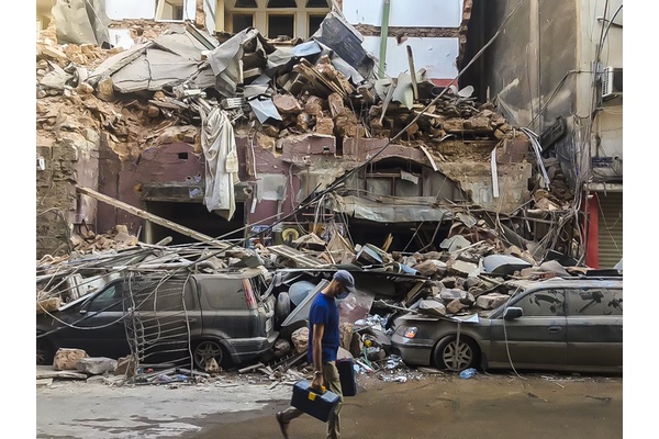 Man walks past part of the explosion site in Beirut