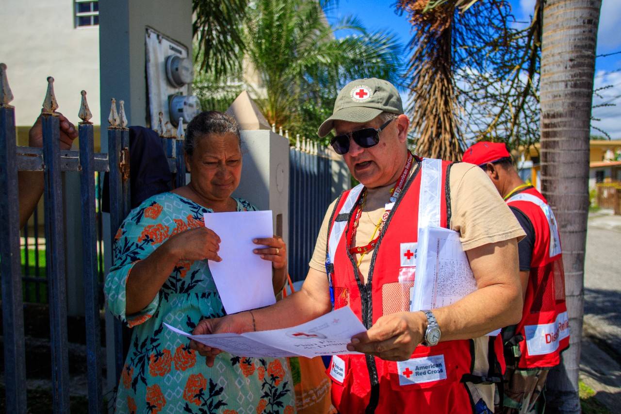 February 1, 2020. Yauco, Puerto Rico. Red Cross team member José, who is from the capital of Puerto Rico, gives Lucila information on how to prepare for future emergencies. Photo by Isaac León/American Red Cross