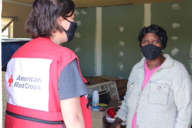 Red Cross volunteer helps woman in home