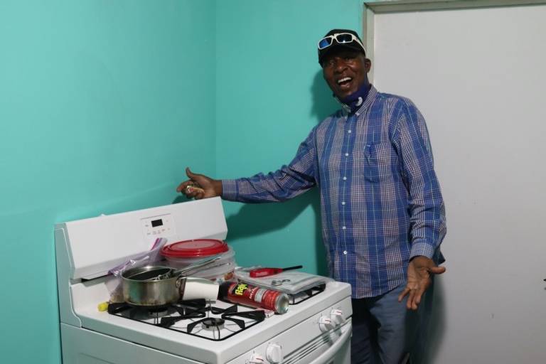 man stands in front of his stove in his home