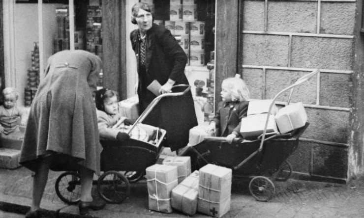 Guernsey residents gather their Red Cross parcels from the SS Vega containing food, salt, soap, cigarettes, medical and surgical supplies and some clothing for children and infants.