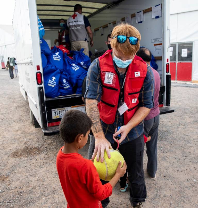 Brian Forristal, veterano de la Marina y voluntario de la Cruz Roja por primera vez, interactúa con niños afganos en el complejo de tiro Doña Ana de Fort Bliss en Nuevo México.