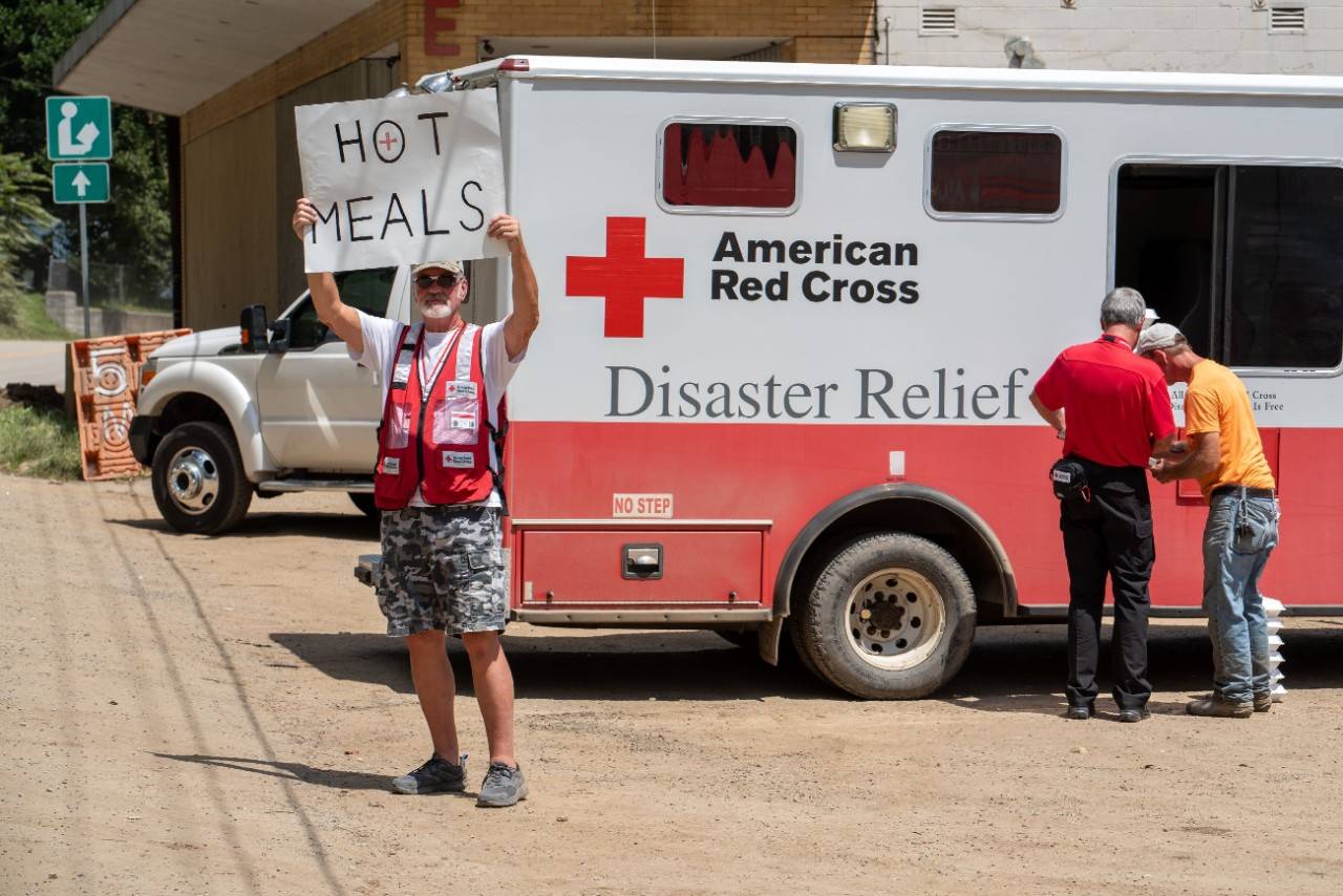 August 4, 2022. Fleming-Neon, Kentucky.
American Red Cross volunteer Ned Worman from Chesapeake, Virginia, makes sure those affected by flooding in eastern Kentucky know the Red Cross that food is available for everyone affected by disaster. Red Cross Emergency Response Vehicles distribute hot meals throughout disaster-stricken communities.
Photo by Kevin Suttlehan/American Red Cross