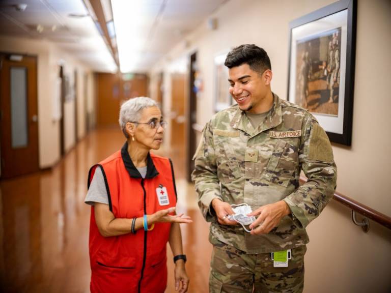 La voluntaria de la Cruz Roja Deborah Trimiar habla con un miembro del servicio en la Base Conjunta Andrews en Maryland.