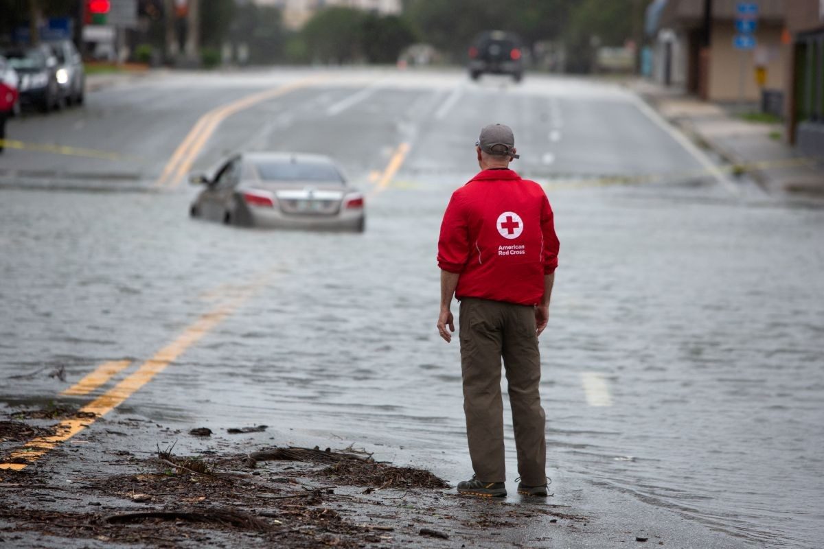 A Red Cross volunteer surveys a flooded neighborhood after Hurricane Ian