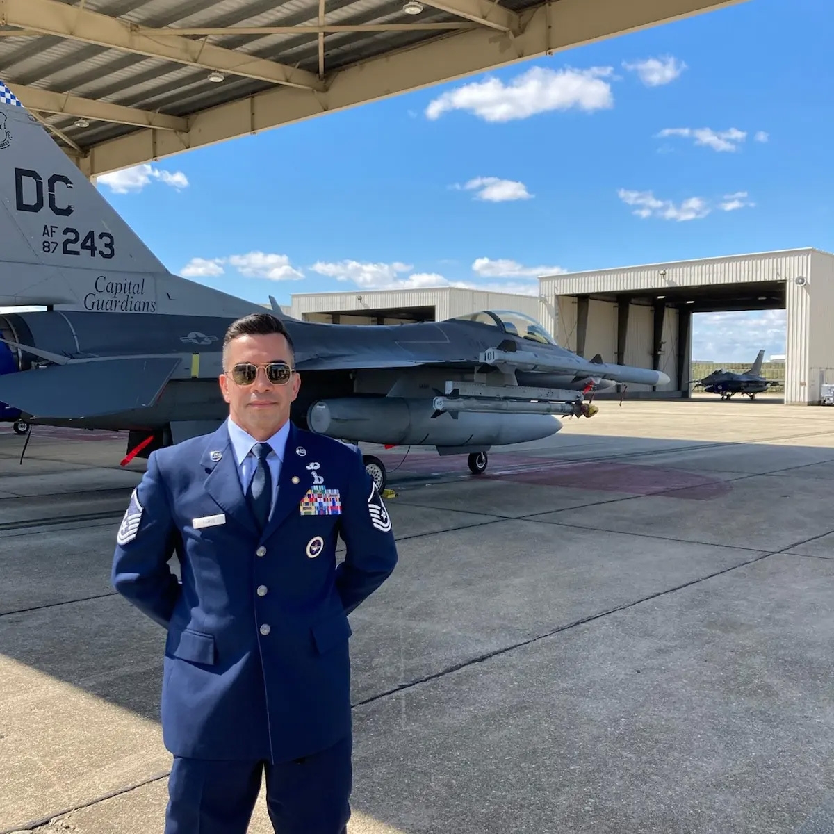 eddie ramos in uniform standing in front of plane