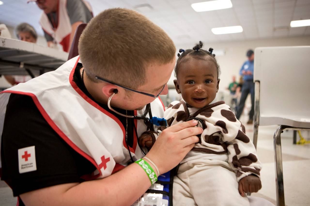 May 6, 2011. Tuscaloosa, Alabama. Red Cross EMT Scott Gay visits with Katelyn Palmer, 7 months, at the Red Cross shelter at Belk Activity Center in Tuscaloosa, Alabama. Photo by Talia Frenkel/American 