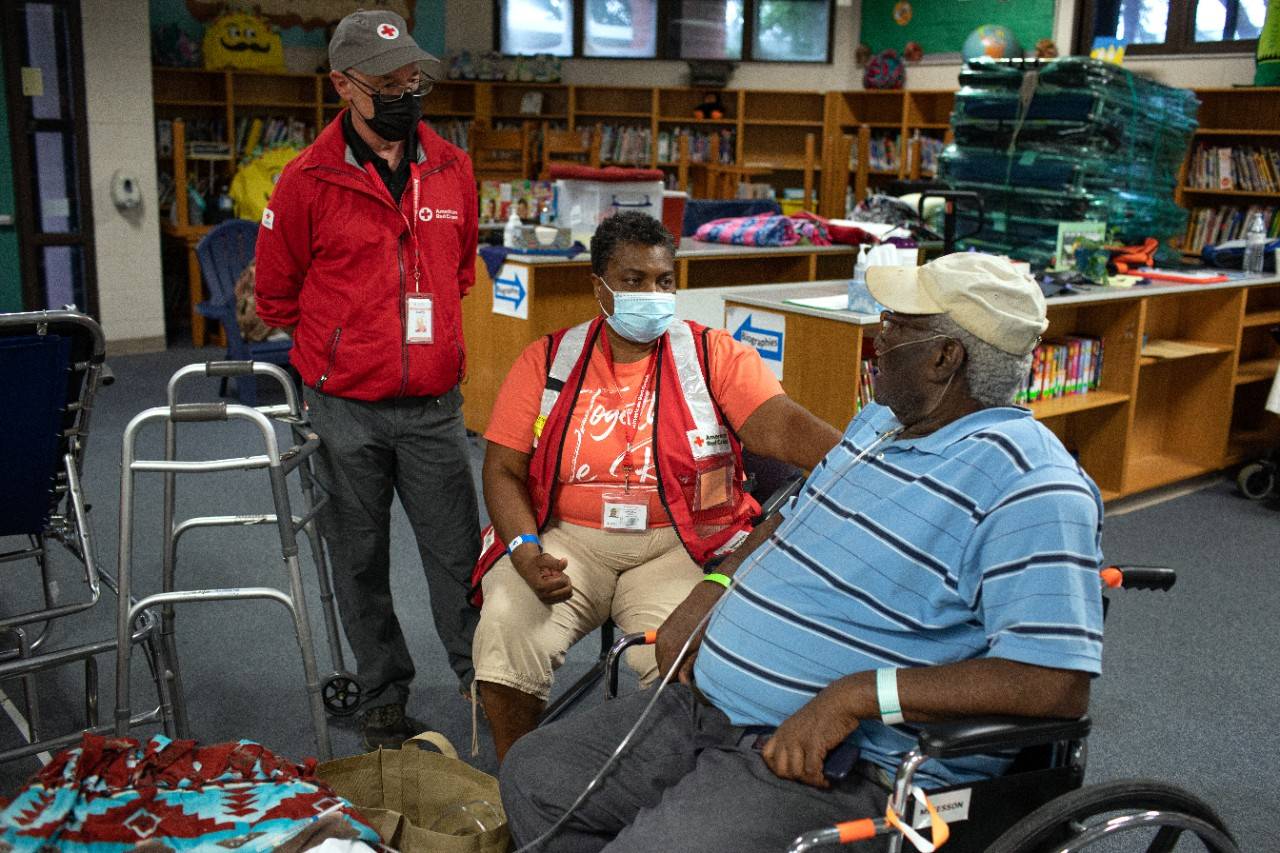 September 28, 2022. Clermont, Florida
Red Cross volunteer Cynthia Myatt checks up on Robert Franks in the evacuation shelter at the Lost Lake Elementary School in Clermont, Fl., where local residents are being sheltered from Hurricane Ian. Franks is 84-years-old and has lived in Florida his entire life. He's survived countless hurricanes on his own, but knew to seek help from the Red Cross for this storm because he's on oxygen and can't be without electricity. "I feel like a kid again being in this school library with all these books," he said as his face lit up. ""I'm comfortable here."
Photo by Marko Kokic/American Red Cross