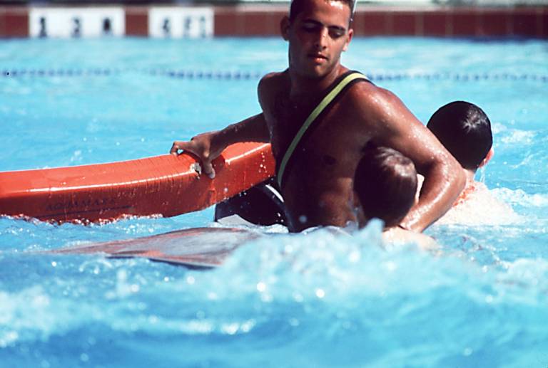lifeguard in pool swims near two children