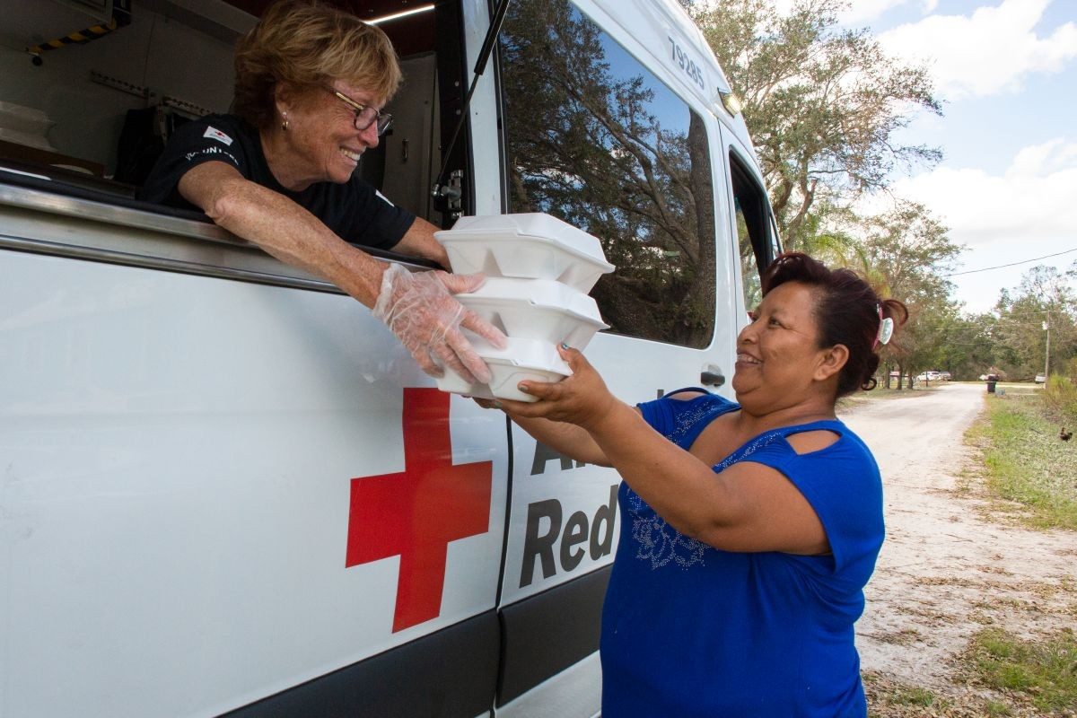 Red Cross volunteer handing out supplies.