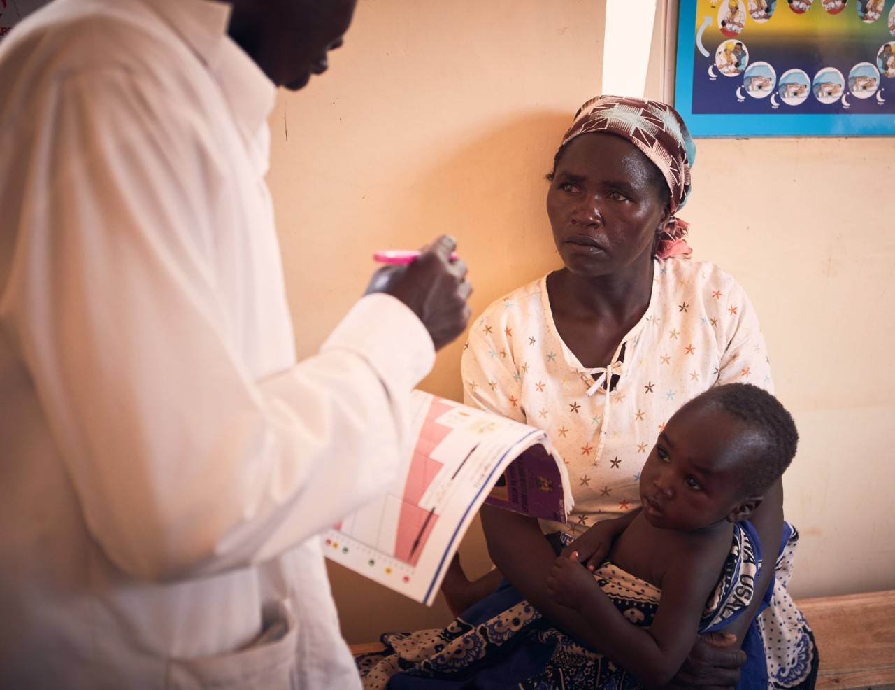 September 18, 2018. Tharaka Nithi, Kenya. Magrate Kagendo Mugambi and her 11-month-old son, Bahati, review vaccination records with a healthcare worker in rural Kenya. Local Red Cross volunteers went door-to-door in Magrate’s community to identify children missing routine immunizations, update vaccination records at local health centers, encourage parents and caregivers to have their children vaccinated, and follow up with families to confirm receipt of the recommended vaccinations. Each year in Kenya, more than 350,000 children miss their scheduled routine vaccinations—leaving them vulnerable to vaccine-preventable diseases such as measles and rubella. The American Red Cross and the Kenya Red Cross have been working together to strengthen community-level routine immunization systems in both rural and urban counties.   Measles is one of the most contagious and severe childhood diseases. Every day, it takes the lives of hundreds of children around the world. Even if a child survives, measles can cause permanent disabilities, such as blindness or brain damage. But there is hope. Since 2001, the American Red Cross and our partners in the Measles & Rubella Initiative have vaccinated more than 2 billion children around the globe. The Red Cross plays a pivotal role in vaccination campaigns worldwide: local volunteers use mass media, rallies, door-to-door visits and educational entertainment to reach families who do not have access to routine health services. Whether in distant villages or urban settlements, these campaigns may be the only way for children to receive this lifesaving vaccine. It costs about $2 to vaccinate a child against measles and rubella, making it one of the most cost-effective health interventions available. Photo by Juozas Cernius / American Red Cross