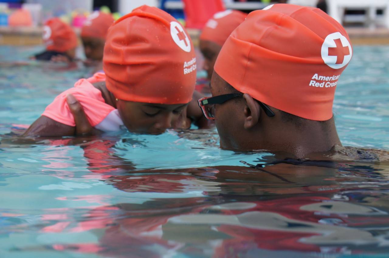 July 16, 2019. Opa Locka, Florida. The Centennial Campaign celebrates more than 100 years of American Red Cross swimming safety education. Cities selected for the campaign have high numbers of fatal drownings or overall drowning rates, most higher than the national average. Working with local aquatics training providers, we ve taught thousands of people in 50 selected cities across 19 states how to swim and be safe in and around the water. 

In this photo, an adult works with a child learning how to breathe properly in the water.
Photo by Eliza Shaw/American Red Cross