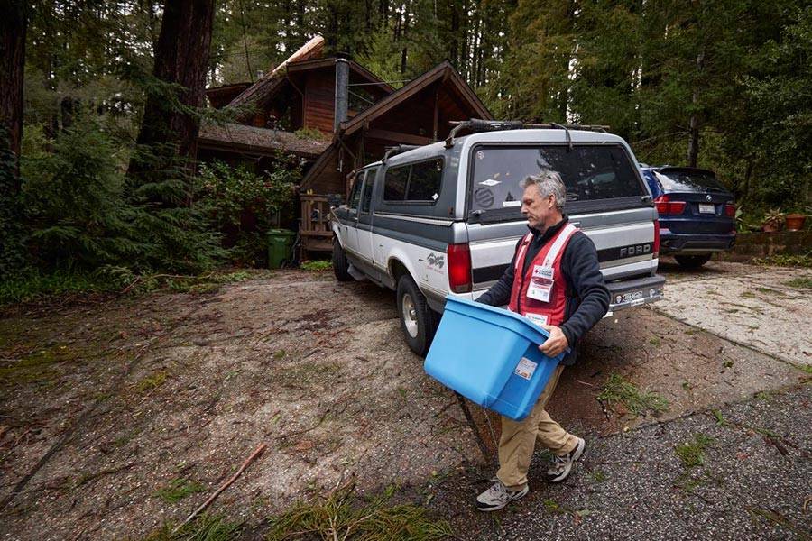 Red Cross volunteer delivers cleanup supplie