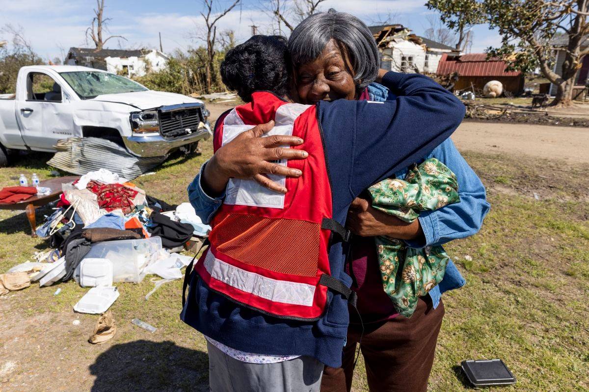 volunteer visits with home owner after tornado