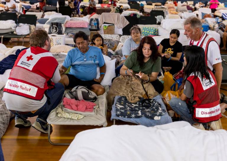 A family speaks with Red Cross staff members at an emergency shelter