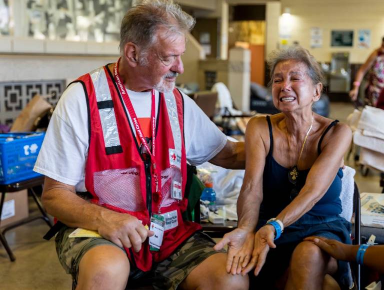 American Red Cross volunteer Ned Worman comforts Elaine Goode