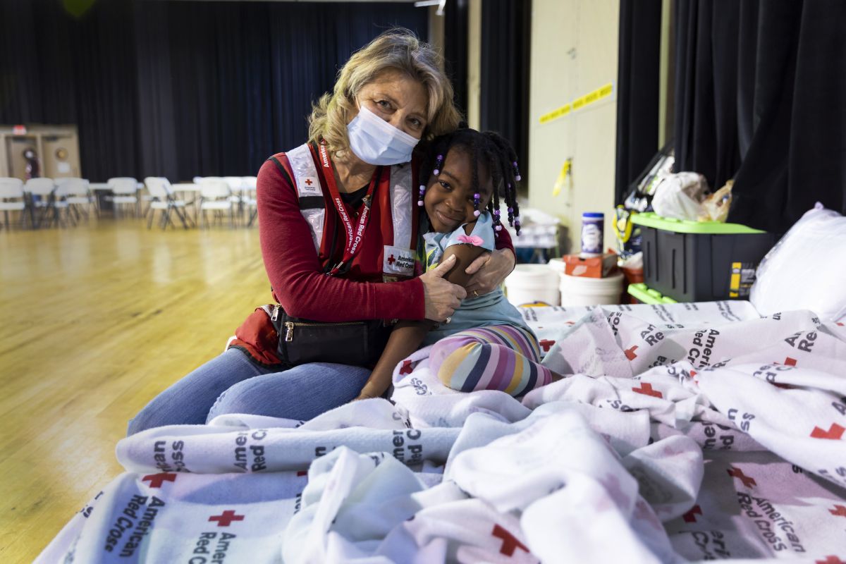 March 30, 2023. Amory, Mississippi. Red Cross volunteer Diane Mercado spends time with 6-year-old Laniya Buckner on Thursday at a Red Cross shelter in Amory, Miss. Shelter residents sang Mercado s praises. One resident, Davonyae Beeks, said Mercado helped get a microwave so that Beeks could heat her meals, a need because since she has generally been at work during the shelter s meal times. Another resident, Marquita Whitehead, said Mercado has gone above and beyond to entertain her two children, and others at the shelter. Whether it s playing games, finding in-demand toys like bubbles or just making them laugh through conversation, Mercado is  real good with the kids,  Whitehead said.  Everybody loves [Mercado],  said Samuel Hughes.Photo by Scott Dalton/American Red Cross