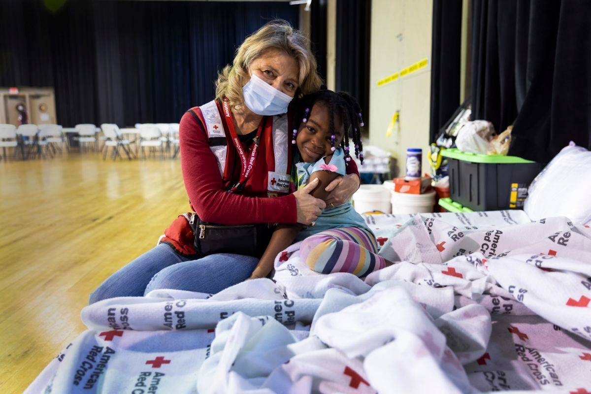 March 30, 2023. Amory, Mississippi. Red Cross volunteer Diane Mercado spends time with 6-year-old Laniya Buckner on Thursday at a Red Cross shelter in Amory, Miss. Shelter residents sang Mercado s praises. One resident, Davonyae Beeks, said Mercado helped get a microwave so that Beeks could heat her meals, a need because since she has generally been at work during the shelter s meal times. Another resident, Marquita Whitehead, said Mercado has gone above and beyond to entertain her two children, and others at the shelter. Whether it s playing games, finding in-demand toys like bubbles or just making them laugh through conversation, Mercado is  real good with the kids,  Whitehead said.  Everybody loves [Mercado],  said Samuel Hughes.Photo by Scott Dalton/American Red Cross