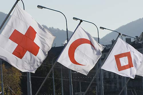 three flags with the red cross emblems - the cross, the crescent, and the gem