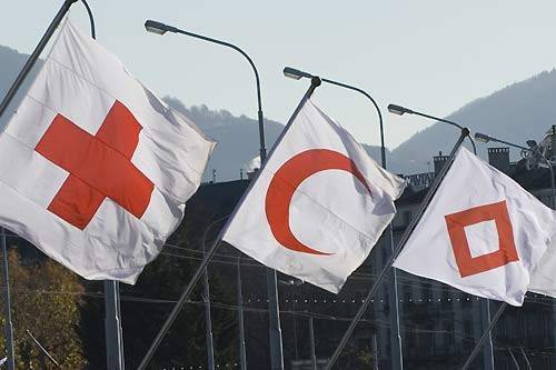 three flags with the red cross emblems - the cross, the crescent, and the gem