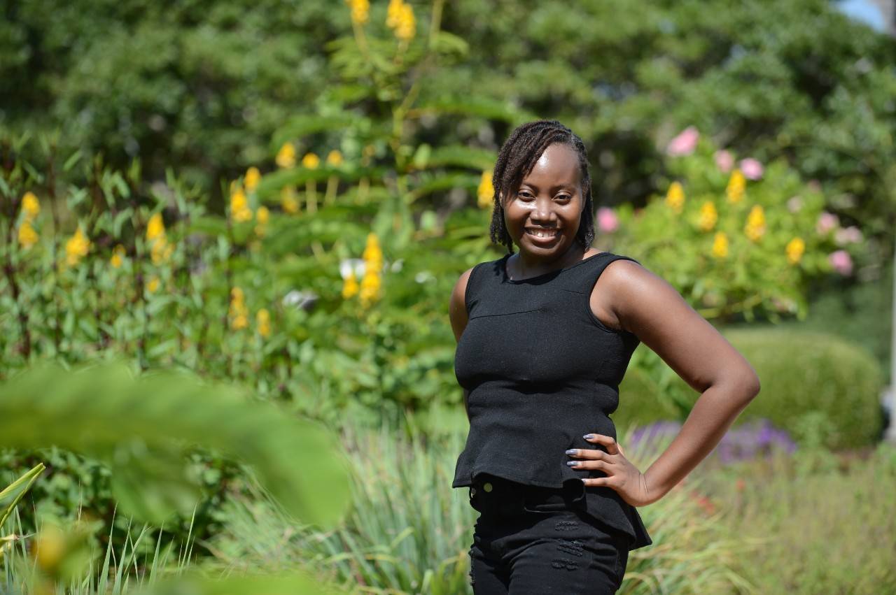 Keyera Jennings standing in a field of flowers smiling