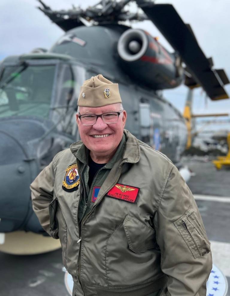 Lieutenant Jim Bound standing in front of a military helicopter