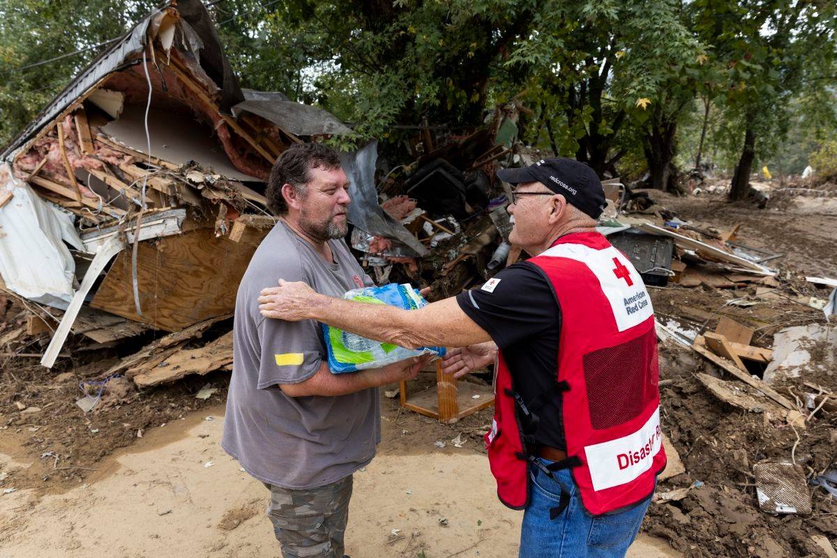 October 4, 2024.  Asheville, North Carolina.
Asheville, North Carolina resident Danny Bailey receives a case of water from Red Cross volunteer Richard Kimball who drove an American Red Cross Emergency Response Vehicle throughout various Asheville neighborhoods to deliver meals, water and clean-up kits to residents impacted by Hurricane Helene.
Photo by Scott Dalton/American Red Cross
