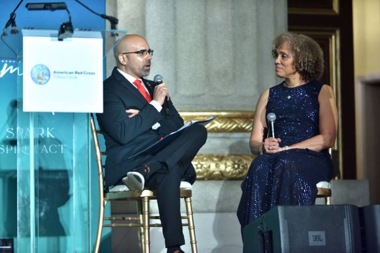 Man and woman sit on a stage