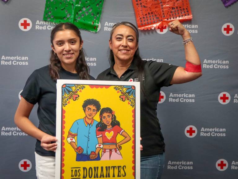Two women with Los Donantes sign