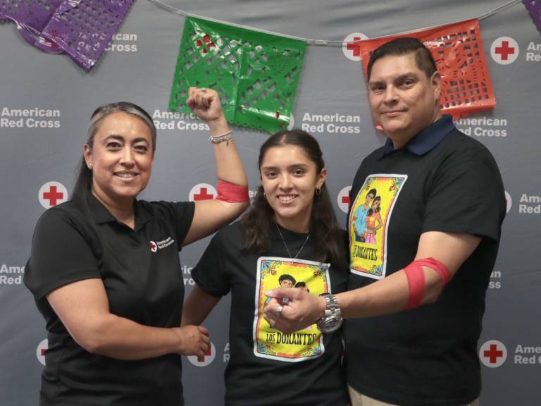 Two women and a man with bandaged arms after giving blood