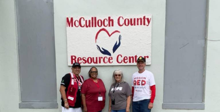 group of people, some wearing Red Cross badges, stand together